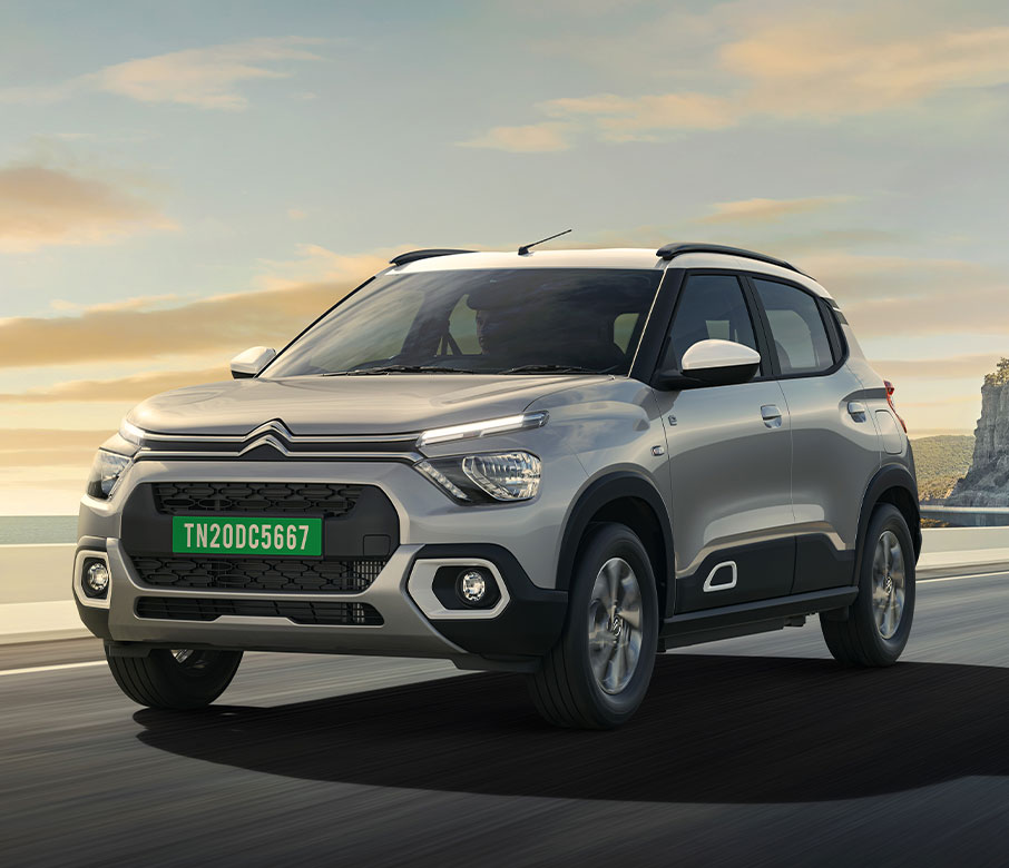 Citroën eC3 electric hatchback in dual-tone finish parked on open road, showcasing modern European styling and high ground clearance